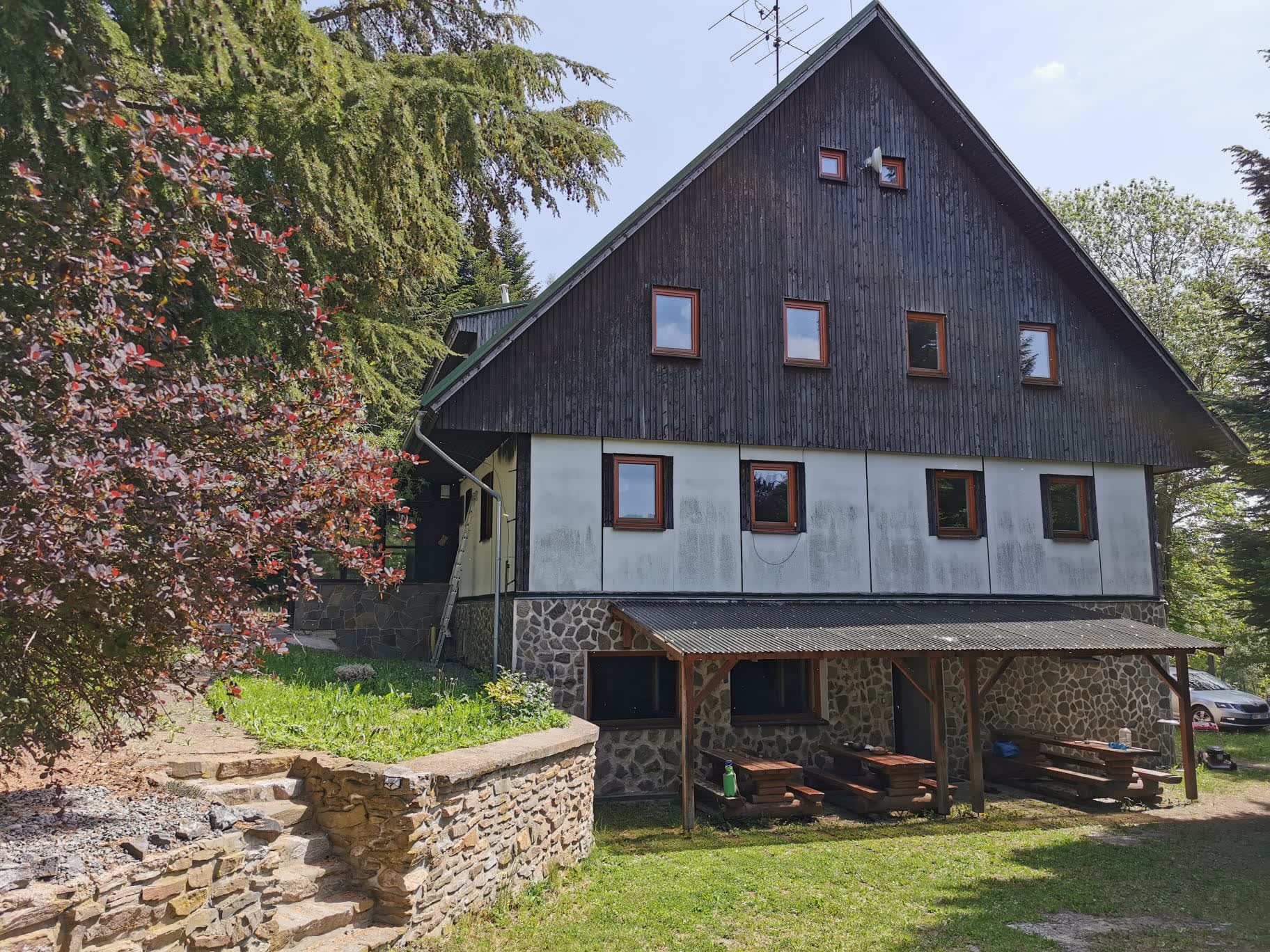 Průčelí Chaty Barborka v Hartmanicích: dřevěný štít, kamenná podezdívka a krytá pergola